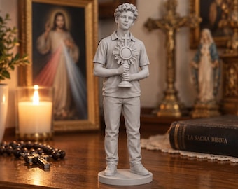 May include: A light gray monochromatic figurine of a young person with curly hair, wearing a polo shirt and trousers, standing on a circular base while holding a monstrance with a cross at the top in both hands.