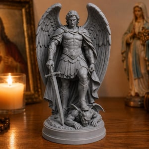 May include: A gray stone-colored statue of an archangel with large wings, wearing armor and a cloak, holding a sword in one hand while standing over a defeated figure on a circular base. The figure is depicted with a muscular build and detailed features.