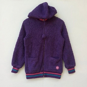 May include: A purple fleece hooded jacket with a zip fastening and a striped trim around the bottom and cuffs. The jacket has two pockets on the front.