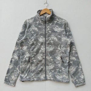 Pode incluir: Uma jaqueta de fleece de camuflagem cinza e branca com fecho de correr e um logotipo da Columbia no peito esquerdo.
