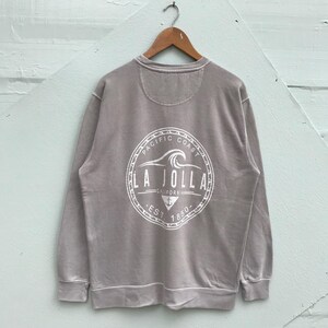May include: A gray sweatshirt with a white graphic on the back. The graphic is a circle with the text "Pacific Coast La Jolla California Est 1850" inside.