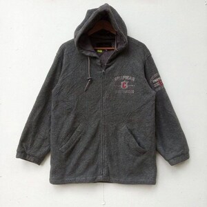 Może przedstawiać: Szara bluza z kapturem zapinana na zamek błyskawiczny, wykonana z polaru. Bluza ma duży napis "Chapman" z przodu i mniejszy napis na rękawie.