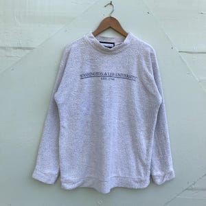 May include: A light gray sweatshirt with the text "WASHINGTON & LEE UNIVERSITY EST. 1749" in navy blue.