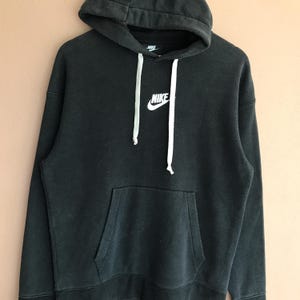 May include: Black Nike hoodie with a drawstring hood and a front kangaroo pocket. The Nike logo is displayed in white on the chest. The hoodie is made of a soft, comfortable material.