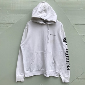 Puede incluir: Una sudadera con capucha blanca con un bolsillo delantero y un cordón. El logotipo de Columbia está en el pecho y el nombre de la marca está impreso verticalmente en la manga izquierda en negro.