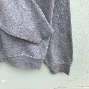 May include: Gray sweatshirt with a ribbed cuff and hem.