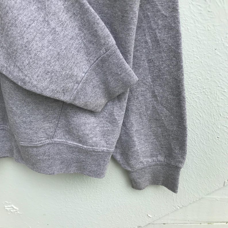 May include: Gray sweatshirt with a ribbed cuff and hem.