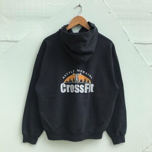 May include: Black hooded sweatshirt with a white logo that says "Kettle Moraine CrossFit" in a circle with an orange background and a silhouette of a person lifting weights.