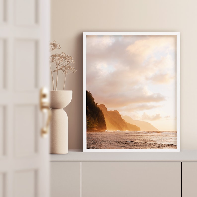 May include: A framed photograph of a scenic coastline with a dramatic cliffside and a golden sunset over the ocean.