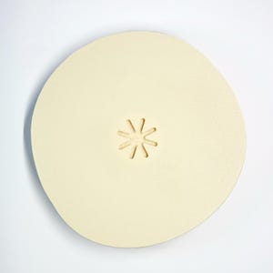 May include: A round, off-white sanding disc with a star-shaped cutout in the center.