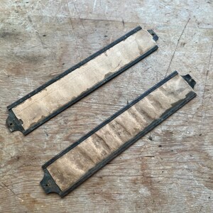 May include: Two antique brass nameplates with a black border and a paper insert. The plates are rectangular and have rounded corners.