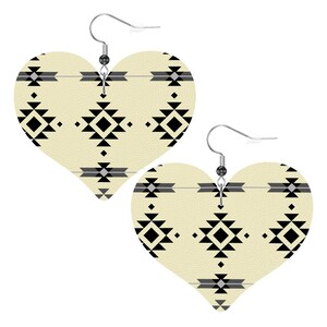 May include: Heart-shaped earrings with a cream-colored background and a black and gray geometric pattern. The earrings have silver-colored hooks.