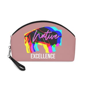 May include: A blush-colored cosmetic bag with a black zipper and wrist strap. The bag features a colorful graphic of a bison with the word "Native" in a neon script and the word "EXCELLENCE" in white block letters.