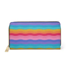 May include: A rectangular wallet with a vibrant rainbow wave pattern. The wallet features a gold-colored zipper and pull. The color scheme includes shades of blue, purple, pink, orange, and yellow.