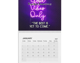 Pode incluir: Um calendário de parede para 2027 com um gráfico de letreiro de néon roxo com o texto Good Vibes Only e Hopeful Tomorrows, juntamente com a citação THE BEST IS YET TO COME. A secção inferior mostra o mês de janeiro com um layout de grelha.