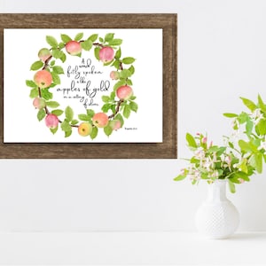 May include: A watercolor painting of a wreath of apples with the quote "A word fitly spoken is like apples of gold in settings of silver." Proverbs 25:11