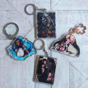 May include: Four different keychains with colorful anime-style illustrations. Each keychain features a different character with a unique design and a silver metal ring.
