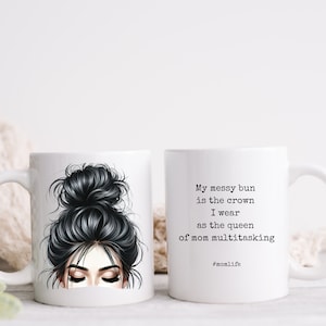 May include: White ceramic mug with a black and white illustration of a woman with a messy bun. The text on the mug reads "My messy bun is the crown I wear as the queen of mom multitasking #momlife".