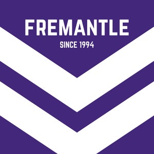 Puede incluir: Un fondo morado con un diseño de chevron blanco. El texto "FREEMANTLE SINCE 1994" está en la parte superior de la imagen.