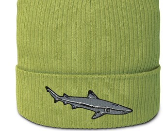 May include: A green knitted beanie with a gray embroidered shark on the front.