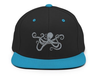 May include: A black and blue baseball cap with an embroidered gray octopus design.