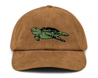 May include: A brown corduroy baseball cap with an embroidered green sea turtle design.