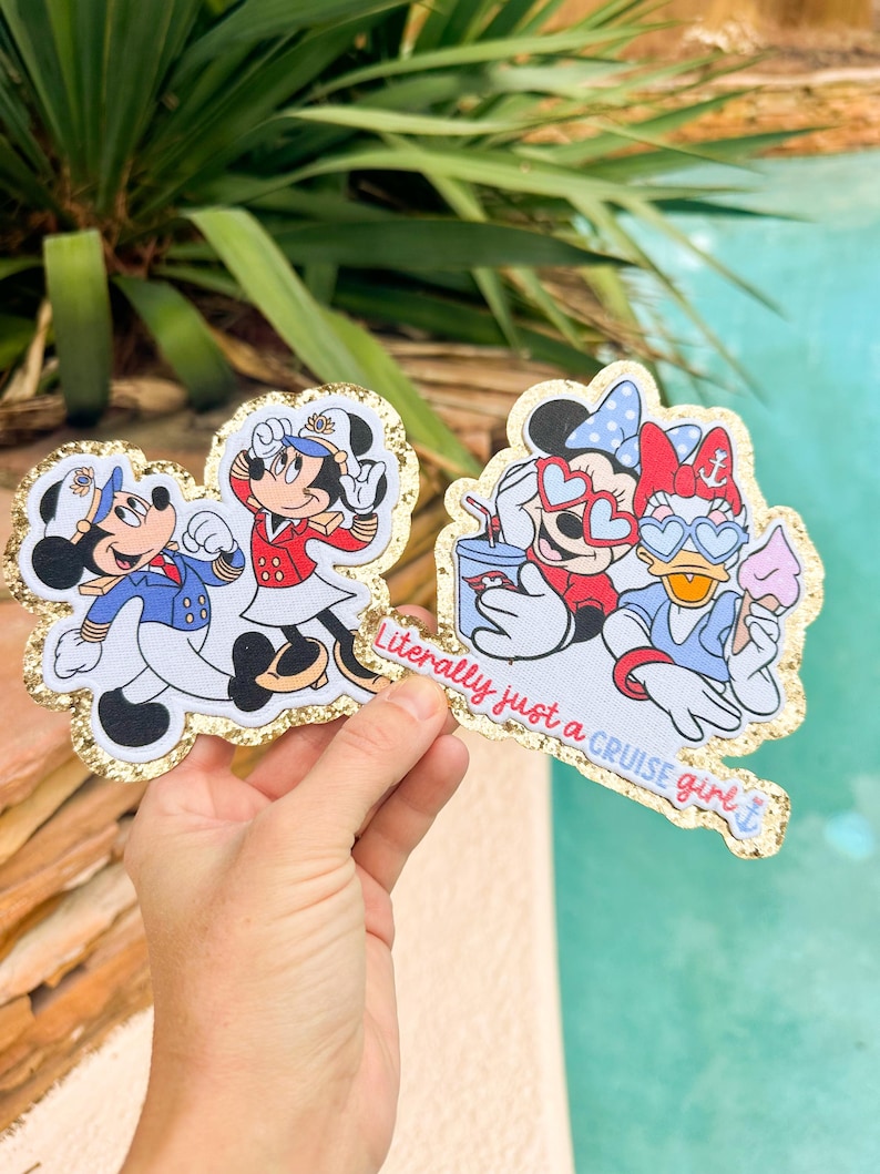 May include: Two die-cut stickers with gold glitter borders. One sticker shows Mickey and Minnie Mouse in cruise ship uniforms. The other sticker features Minnie Mouse and Daisy Duck wearing heart-shaped sunglasses with the text Literally just a CRUISE girl.