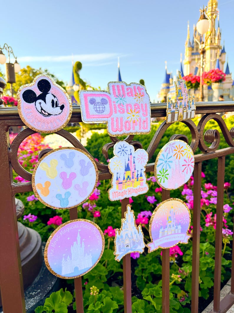 May include: Nine colorful embroidered iron-on patches featuring Mickey Mouse, fireworks, Cinderella's Castle, and the words "Walt Disney World" and "Magic Kingdom".