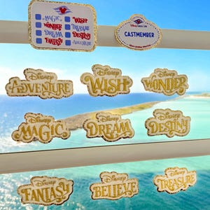 May include: A selection of Disney Cruise Line badges and pins with gold glitter detailing. The pins display words such as "Adventure", "Wish", "Wonder", "Magic", "Dream", "Destiny", "Fantasy", "Believe", and "Treasure". A "Castmember" badge is also present.