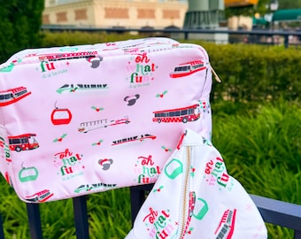 May include: A light pink rectangular pouch and a white crescent-shaped waist bag, both featuring a repeating pattern of colourful theme park transportation vehicles, holly leaves, and the text "oh what fun it is to ride" in red and green.