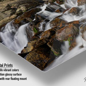 May include: Metal print featuring a cascading waterfall over rocks. The water appears white and foamy, contrasting with the brown and tan rocks. The print has a high-definition glossy surface and is ready to hang with a rear floating mount.