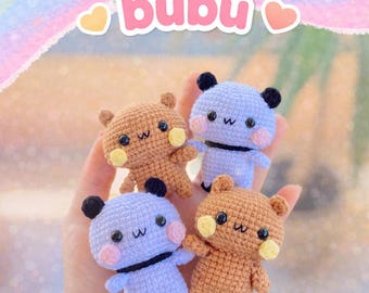 Può includere: Quattro bambole amigurumi a forma di orso all'uncinetto, marroni e lavanda, ciascuna con orecchie nere e una striscia nera. Le bambole hanno facce ricamate e guance gialle. L'immagine include il testo "dudu and bubu" e "PDF Pattern".
