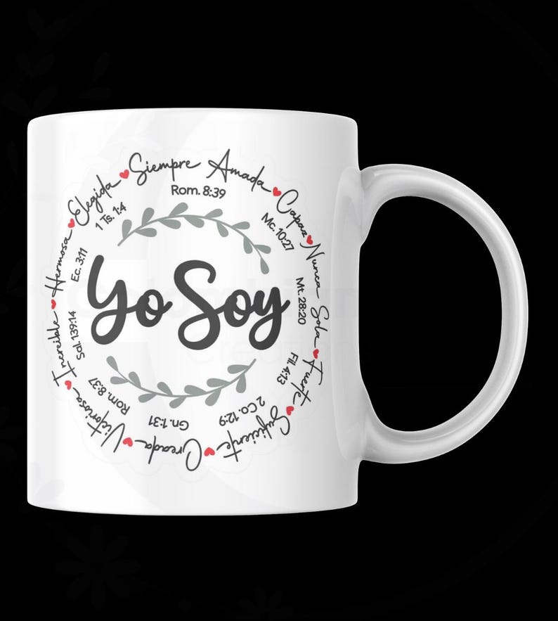 May include: White ceramic mug with the words "Yo Soy" in a stylized font. The mug features a circular design with Spanish words and Bible verses, including "Elegida" and "Siempre Amada". The handle is on the right side.