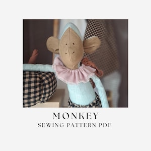 Puede incluir: Un muñeco de mono de tela con cara color canela, brazos y torso azul claro, y un cuello con volantes rosa. El mono lleva pantalones de cuadros negros y blancos y está junto a una calabaza de cuadros negros y blancos. Texto MONKEY SEWING PATTERN PDF.