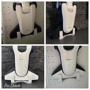 Peut inclure: Quatre têtes d'aspirateur blanches avec des accents noirs sont montées sur des murs. Les têtes d'aspirateur sont étiquetées "Kobold" et portent un logo vert et blanc. Les murs sont blancs et présentent un motif de petits trous.