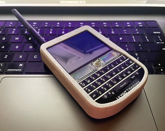 Könnte beinhalten: Ein weißes und schwarzes Handy mit einer QWERTY-Tastatur und dem Text "LILYGO T-Keyboard" auf der Unterseite. Das Handy liegt auf einer Laptop-Tastatur.