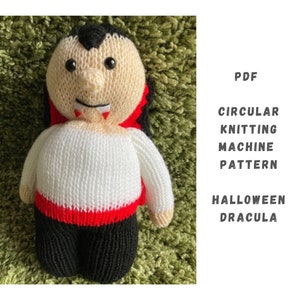 Pode incluir: Um padrão de boneca Dracula de Halloween para máquinas de tricô circulares. O padrão está disponível para download em PDF. A boneca está usando uma capa vermelha e tem uma camisa branca e calças pretas.