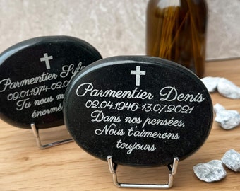 May include: Two black oval-shaped stones with engraved text and a cross on top. The stones are on metal stands. The text on the stones reads "Parmentier Syl 09.01.1974-02.0 Tu nous m' enormé" and "Parmentier Denis 02.04.1946-13.07.2021 Dans nos pensées, Nous t'aimerons toujours".