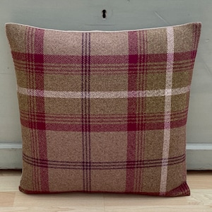 May include: A brown and burgundy plaid cushion with a white border.