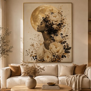 Peut inclure: Grande impression d'art encadrée représentant le profil d'une femme devant une lune dorée. La femme est ornée d'éléments floraux crème et dorés. L'œuvre est exposée au-dessus d'un canapé beige avec des coussins décoratifs.