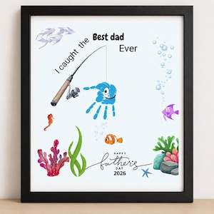 May include: A framed print featuring a fishing rod and a blue handprint shaped like a fish. The text reads I caught the Best dad Ever and Happy Fathers Day 2026. The design includes colorful illustrations of coral, seaweed, a seahorse, and small fish.