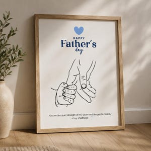 Peut inclure: Une affiche encadrée avec un cœur bleu clair, le texte Happy Father's day en bleu foncé, un dessin au trait noir d'une main adulte tenant une main de bébé, et le texte You are the quiet strength of my future and the gentle melody of my childhood.