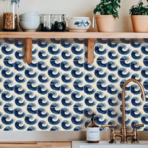 Puede incluir: Un conjunto de azulejos cuadrados con un patrón repetitivo de olas oceánicas estilizadas en azul oscuro sobre un fondo crema. Los azulejos están dispuestos en una cuadrícula, creando un diseño gráfico continuo en el salpicadero.