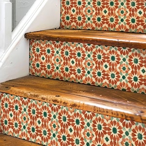 May include: A wooden staircase featuring decorative riser decals with a repeating geometric star pattern in shades of terracotta, dark green, and cream. The stickers are applied to the vertical faces of each step, contrasting with the natural wood treads.