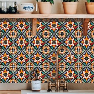 Peut inclure: Un dosseret de cuisine avec un motif de carreaux géométriques colorés en rouge, jaune, bleu et noir. Le motif présente des formes en forme d'étoile. Un évier blanc et un robinet en laiton sont au premier plan, avec des plantes sur une étagère en bois au-dessus.