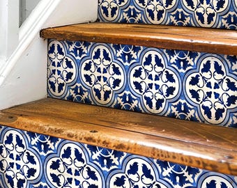 May include: A set of blue and white patterned tile stickers for stairs. The stickers feature a repeating design of stylized flowers and leaves. The stickers are applied to wooden stairs.