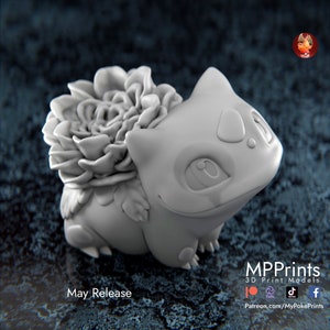 Könnte beinhalten: Ein 3D-gedrucktes Modell eines grauen Pokémon-Charakters mit einer Blume auf dem Rücken. Das Modell sitzt auf einer grauen Oberfläche. Der Text "May Release" ist unter dem Modell sichtbar.