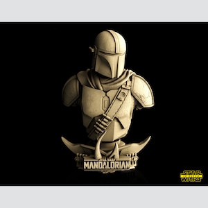 K&ouml;nnte beinhalten: Eine 3D-gedruckte B&uuml;ste des Mandalorianers aus Star Wars. Die B&uuml;ste ist aus hellbraunem Kunststoff gefertigt und zeigt den Helm, die R&uuml;stung und die Waffen des Mandalorianers. Die B&uuml;ste steht auf einem schwarzen Sockel mit der Aufschrift "Star Wars Mandalorianer".