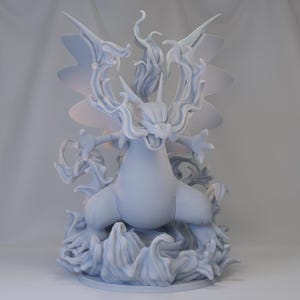 Peut inclure: Une figurine blanche en 3D imprimée d'un Pokémon de type feu avec des flammes et une base ressemblant à de l'eau.