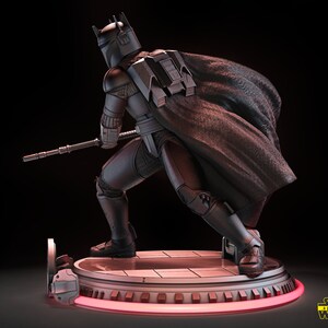 May include: A black and silver Star Wars action figure of a Mandalorian with a cape, holding a weapon, standing on a circular base with a red light.